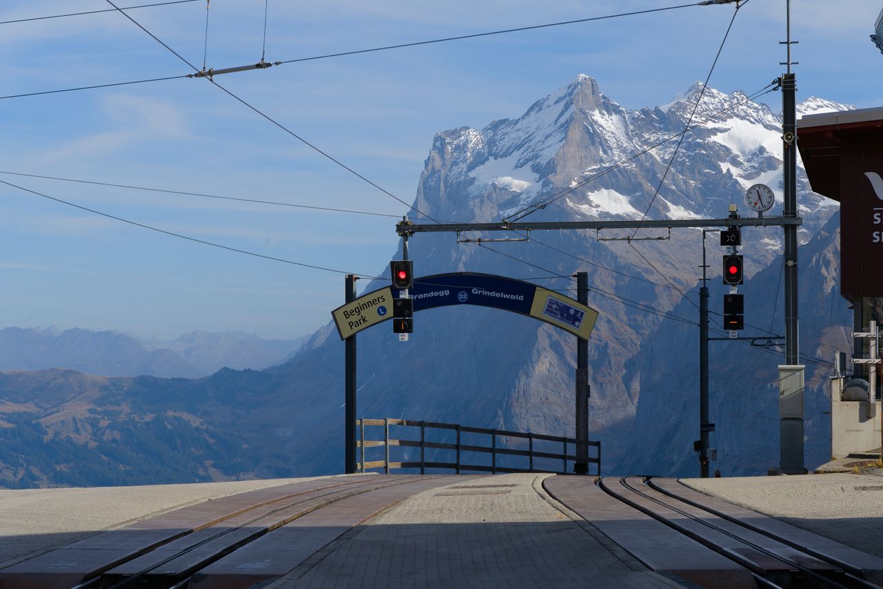 Scenic view of train station with Swiss Alps in the background. Perfect for travel enthusiasts.